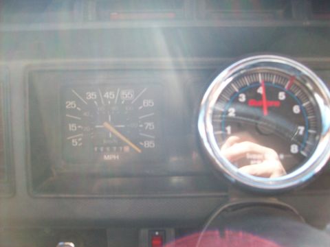 1985 Ford Bronco - Dashboard view of a 1985 Ford Bronco, the speedometer and an aftermarket tachometer.