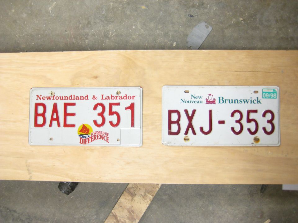 Two license plates, one from Newfoundland & Labrador reading BAE 351, and one from New Brunswick reading BXJ-353 with a 09/98 sticker