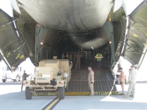 2003 Jeep Wrangler - Military truck being loaded into a cargo plane with assistance from ground crew.