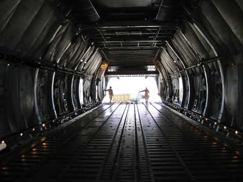 2003 Jeep Wrangler - View from inside a cargo plane's hold, looking out towards the open ramp and the bright exterior.
