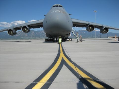2003 Jeep Wrangler - A large C-5 Galaxy military transport aircraft is parked on an airport tarmac under a clear blue sky.