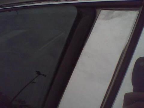 2003 Ford Crown Victoria - The chrome trim on the door frame of a vehicle is shown in this close-up shot.