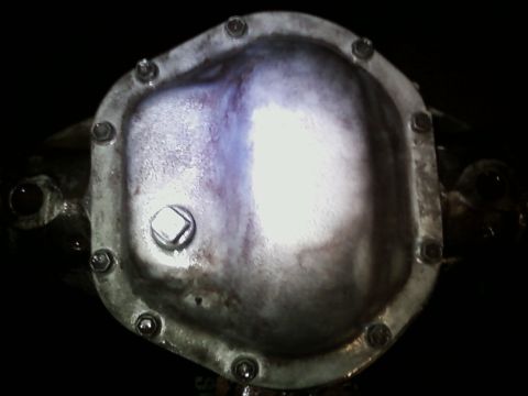 1990 Ford Bronco - This is a close-up view of a vehicle's differential cover, showing the bolts and a square plug.