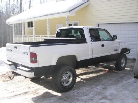 1990 Chevrolet Suburban - This Dodge Ram pickup truck has a toolbox in the bed and is parked in a snowy driveway.