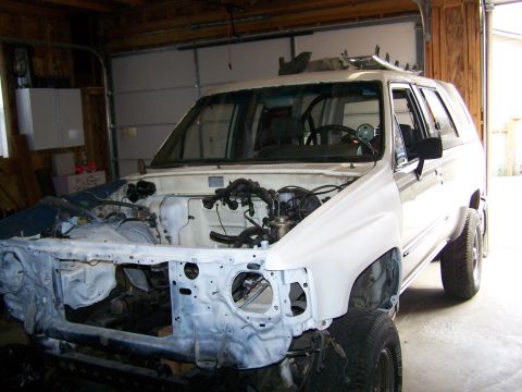 1988 Suzuki Samurai - White SUV in garage with front end removed, undergoing mechanical work.