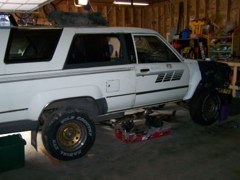1988 Suzuki Samurai - This white SUV, possibly a 1988 model, is shown in a garage with a black fender and gold wheels.