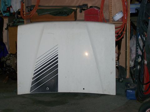1988 Suzuki Samurai - A white vehicle hood with a black graphic design is shown in a cluttered garage setting.