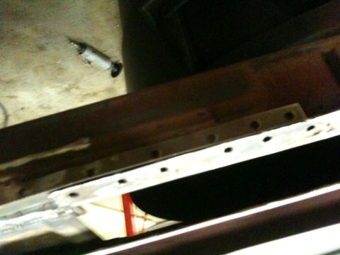 1993 Ford Bronco - Close-up of a metal frame with numerous holes, alongside a drill tool. The Supermotors.net logo is visible in the lower right corner.