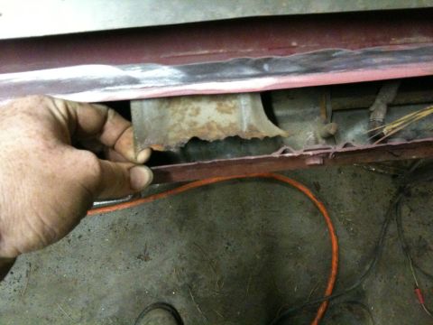 1993 Ford Bronco - Close-up of severe rust damage on a vehicle's lower body panel.