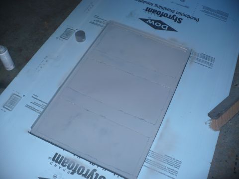 1979 Ford Bronco - A panel is being prepared or painted, resting on a sheet of insulation material with a spray can and brush visible.