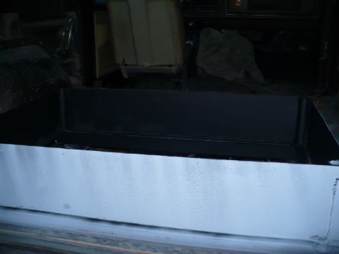 1979 Ford Bronco - The interior cargo area of a vehicle shows a newly installed black metal box, with light gray painted sides.