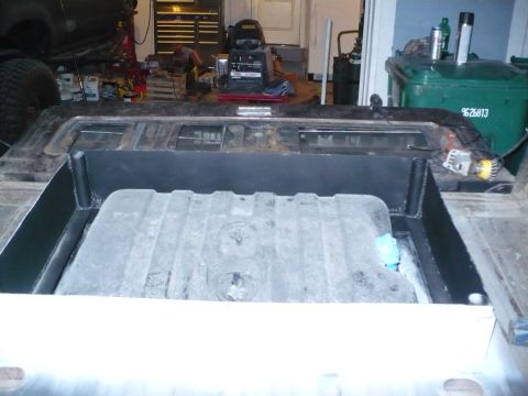 1979 Ford Bronco - The image shows a vehicle's interior with a large fuel tank being installed in the cargo space.