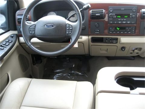1979 Ford F-150 - The interior of a Ford truck, beige leather seats and a wood-trimmed dashboard with modern controls.