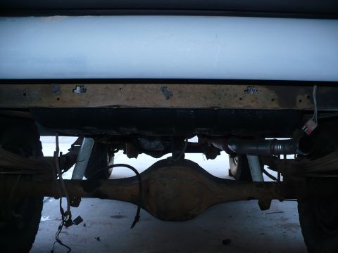 1979 Ford Bronco - Undercarriage view showing the rear axle, leaf springs, and exhaust system of a vehicle.