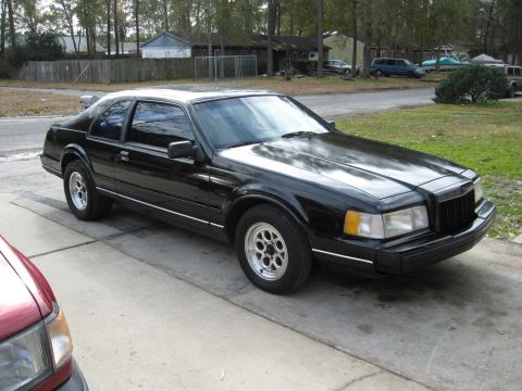 1990 Lincoln Mark VII - 1990 Lincoln Mark VII coupe parked on a driveway with houses in the background.