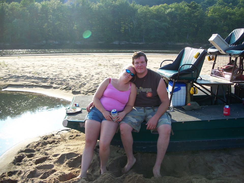Couple sitting on a boat dock by a river