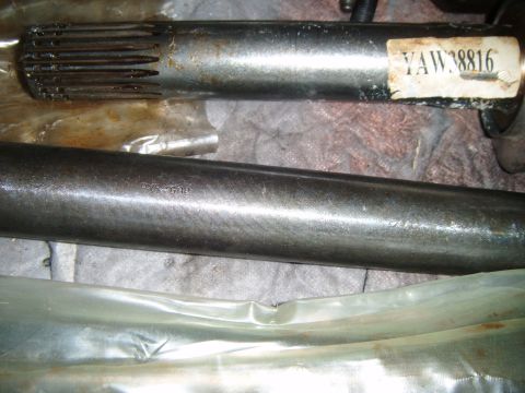 1994 Ford Bronco - Close-up of two axle shafts, one labeled YAW 38816 and the other with PVS-G1P stamped on it.