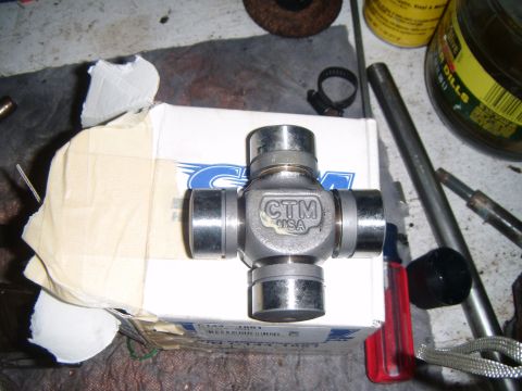 1994 Ford Bronco - A CTM USA universal joint is shown on its box, surrounded by various tools and a jar of liquid.