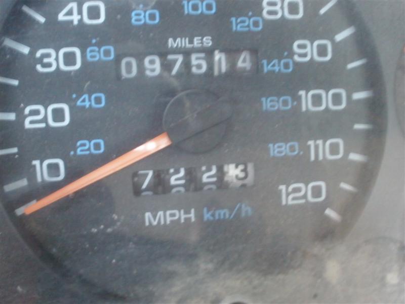 Dusty speedometer face reading 097514 miles with orange needle at zero