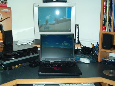 1998 Ford Taurus - black laptop open on a desk in front of a Sony CRT monitor, beside a turntable, speakers, and a shelf of Chilton repair manuals.