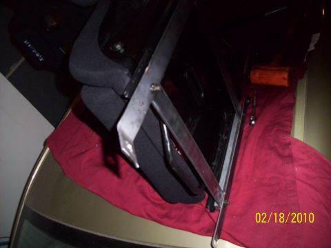 1995 Ford Probe - A close-up view of a custom metal bracket being fitted inside a vehicle, obscuring the car's interior.