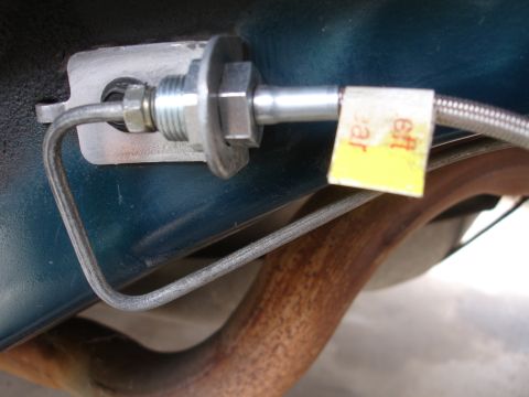 1995 Ford Taurus - Brake line connection detail on vehicle undercarriage, showing a yellow tag with partial text.