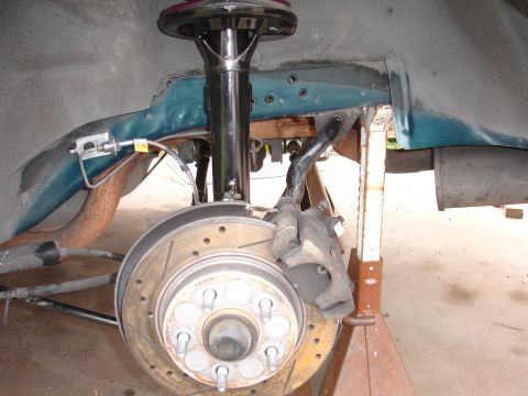 1995 Ford Taurus - Close-up view of a car's front suspension system, showing the brake assembly and shock absorber.