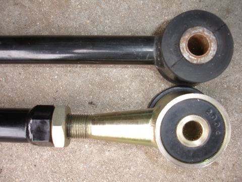 1995 Ford Taurus - Close-up of two suspension arms, one showing an adjustable threaded end with a nut and the other a fixed end with a bushing.