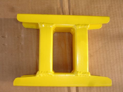 1995 Ford Taurus - A yellow metal part, likely a brace or support, is shown against a cardboard background.