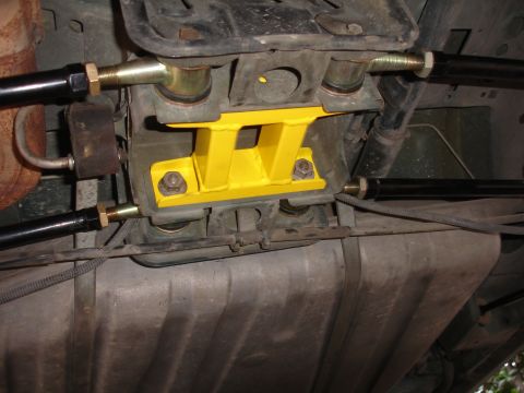 1995 Ford Taurus - Aftermarket yellow rear suspension brace installed on a vehicle's underbody, adjustable black control arms.