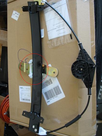 2003 Ford Crown Victoria - Window regulator mechanism part, likely for a car door, shown on a box.