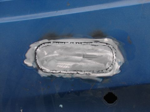 1973 Ford Ranchero - A metal patch has been welded and ground smooth on the blue exterior of a vehicle.