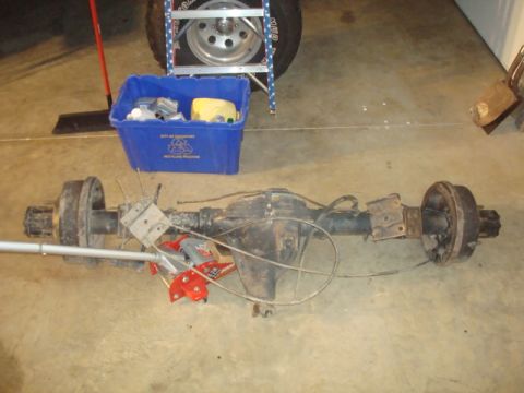 1995 Ford Bronco - A rear axle assembly, likely from an older truck or SUV, is shown on a garage floor.