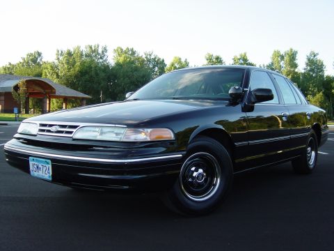 1996 Ford Crown Victoria - Front 3/4 view of a black 1996 Ford Crown Victoria sedan parked on asphalt.