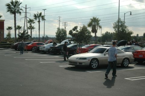 2006 Cadillac STS - A gathering of cars in a parking lot on a cloudy day.