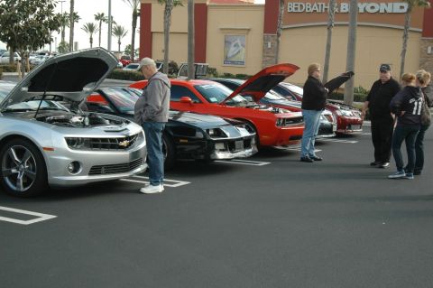 2006 Cadillac STS - Cars are displayed with their hoods open in a parking lot, attracting onlookers.