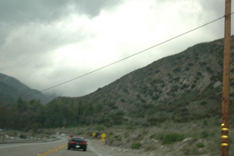 2006 Cadillac STS - Driving through a scenic mountain pass on a cloudy day.