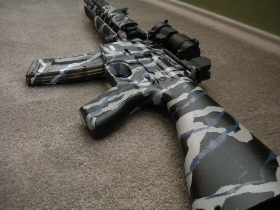 Assault rifle with black, white, and blue camouflage paint