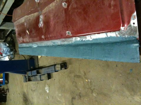 1993 Ford Bronco - Car door panel being prepped for paint, showing rust repair and primer application.