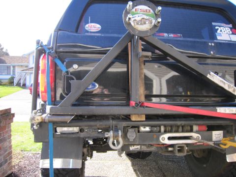 1996 Ford Bronco - Custom rear bumper assembly on a black SUV, a winch, tow hitch, and a spare tire carrier.