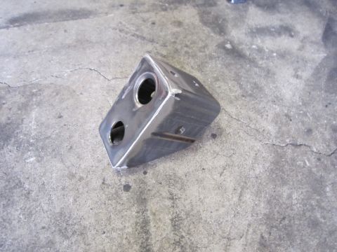 1996 Ford Bronco - A custom metal bracket with two circular openings sits on a cracked concrete surface.