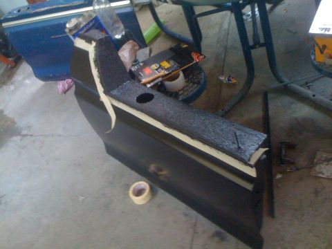 1978 Ford Bronco - A car door panel is being worked on, with masking tape applied to its edges.