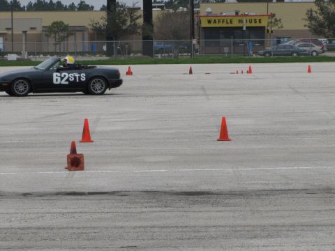 2003 Mazda Protege - A black convertible sports car with white racing numbers navigates a course marked by traffic cones.