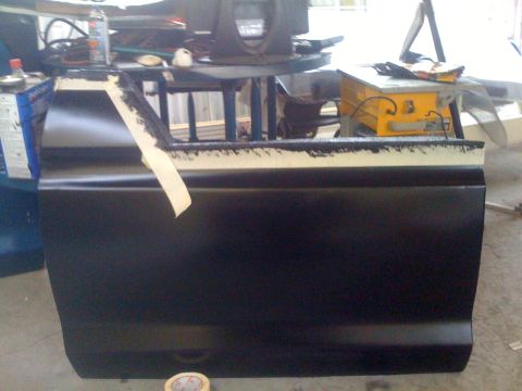 1978 Ford Bronco - A car door is prepped for painting in a workshop environment.