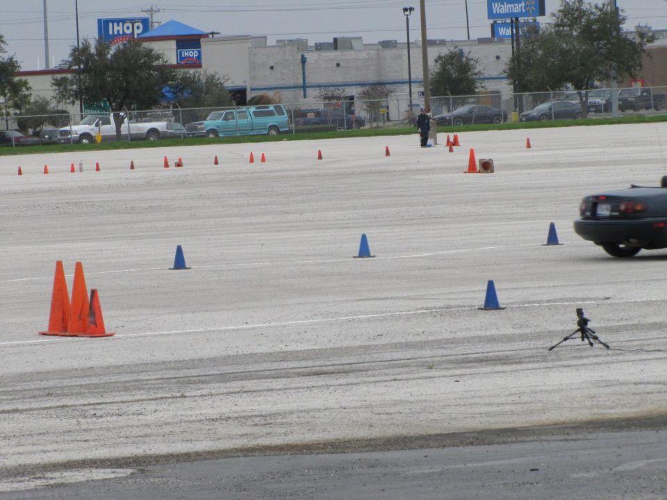 Dark convertible sports car seen from the rear at a cone course