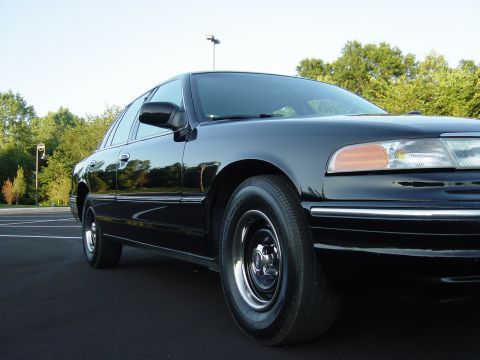 1996 Ford Crown Victoria - Front quarter view of a black 1996 Ford Crown Victoria parked on asphalt.