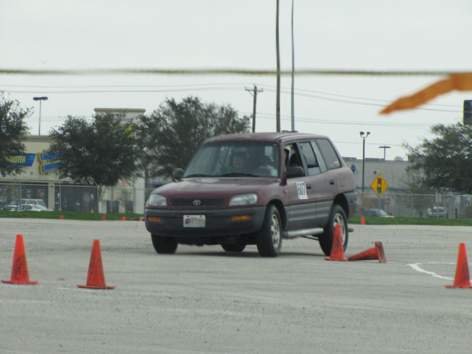 Maroon Toyota RAV4 on a track with orange cones. Number 607 is on the door