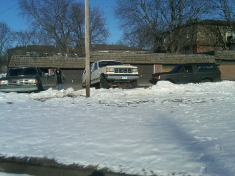 1987 Ford Bronco - Three 1987 Ford Broncos are parked in the snow outside a building.