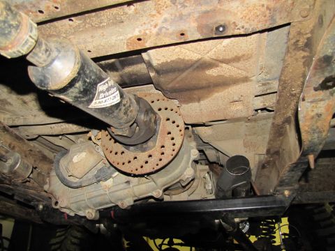 1995 Ford Bronco - Close-up view of the drivetrain components and undercarriage of a vehicle, with visible rust and aftermarket parts.