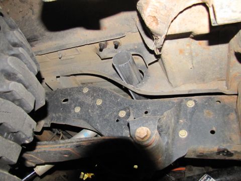 1995 Ford Bronco - Undercarriage detail of a vehicle, focusing on suspension and tire.